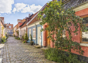 Eine idyllische Kopfsteinpflasterstraße mit bunten Häusern in der Altstadt von Aalborg