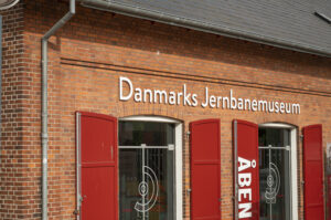 Das dänische Eisenbahnmuseum ist ein rotes Backsteingebäude hinter dem Bahnhofszentrum von Odense